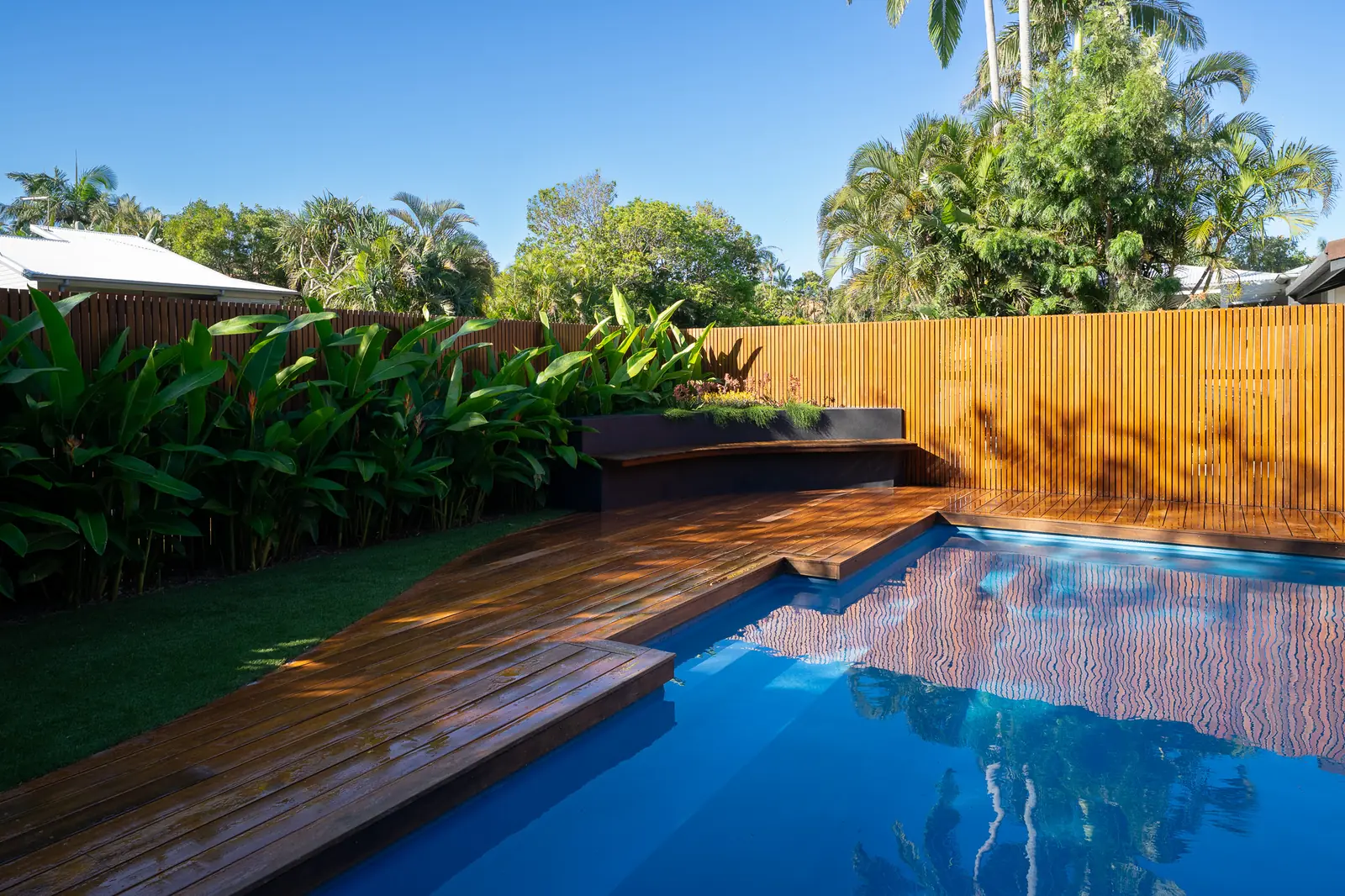 A pool, hardwood deck and rendered bench built as one outdoor space